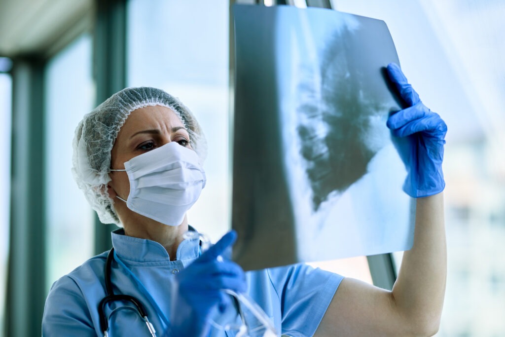 Female doctor examining patient's chest X-ray at the hospital.